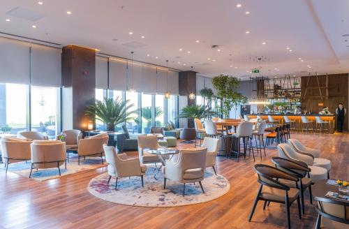 un hall avec des tables et des chaises ainsi qu'un bar dans l'établissement Wellness Park Hotel Bactria, à Samarcande