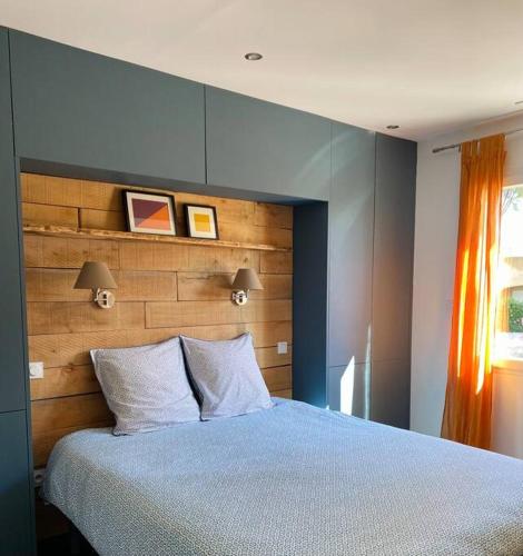 une chambre avec un grand lit avec une tête de lit en bois dans l'établissement CASA LUIS - Bel appartement avec piscine et proche de la mer, à Argelès-sur-Mer