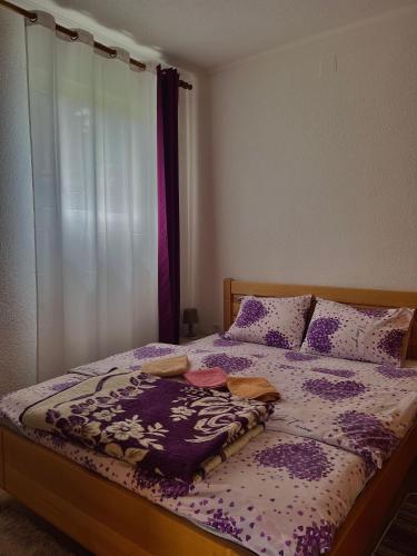 a bedroom with a bed with a purple and white comforter at Vuković Accommodation in Žabljak