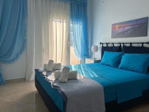 a blue bedroom with a bed with towels on it at Delphitea Philoxenia in Itea