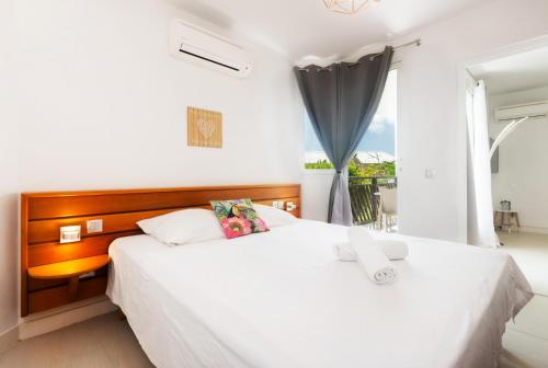 a bedroom with two white beds and a window at Tropical Cocooning in Saint-François