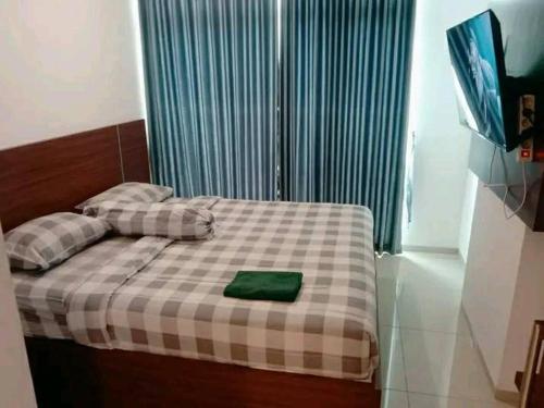 Un dormitorio con una cama con una almohada verde. en Ryan dan Ilham Apartemen, en Dadap