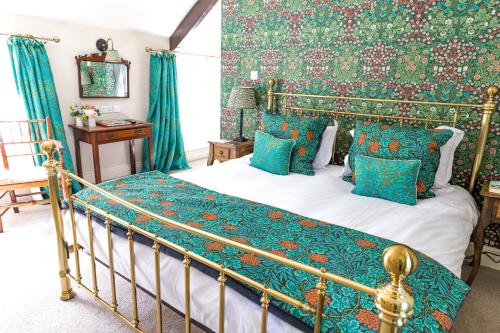 a bedroom with a bed with blue and green pillows at Tickton Grange Hotel in Beverley