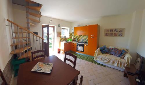 ein Wohnzimmer mit einem Tisch und einer Küche in der Unterkunft il Fienile di Penelope in Marliana