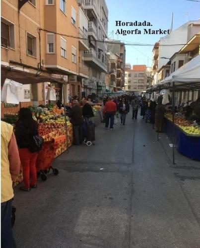 a group of people walking around an outdoor market at Casa Horadada in Algorfa