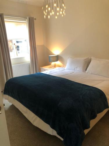 a bedroom with a large bed with a blue blanket at HALF PRICE OFFER - Exeter City Apartment in Exeter