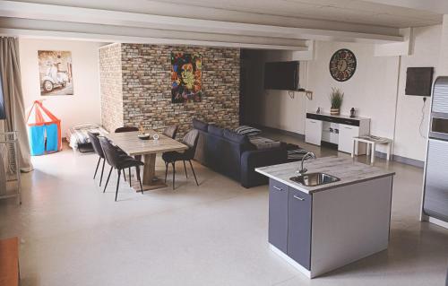 cocina y sala de estar con mesa y sofá en Loft chez Valy et Hervé, en Charleville-Mézières
