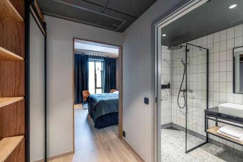 a bathroom with a shower and a bedroom at Quality Hotel Richard With in Stokmarknes