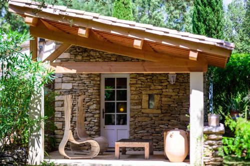 a small stone shed with awning and a bench at Villa Vanille in Boisseron
