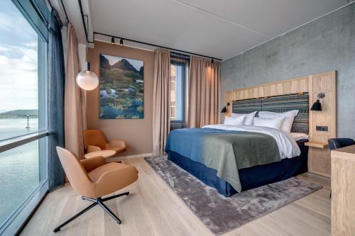 a bedroom with a bed and a chair and a window at Quality Hotel Richard With in Stokmarknes