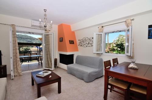 ein Wohnzimmer mit einem Tisch und einem Stuhl in der Unterkunft Villa Ektoras by EY Villas in Parga