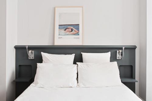 a bedroom with a bed with white sheets and pillows at Hotel De Verdun 1882, BW Signature Collection in Lyon