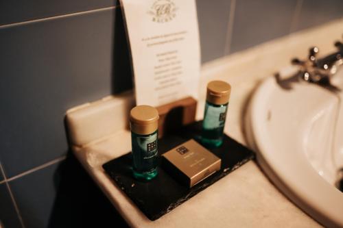 lavabo con 2 botellas en una encimera junto a un fregadero en Casa Grande Do Bachao en Santiago de Compostela