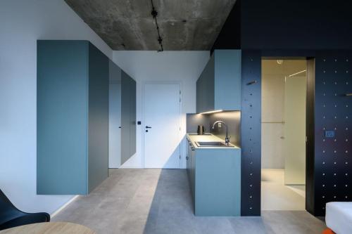 Delo 2.0. في ليوبليانا: مطبخ بجدران زرقاء ومغسلة في الغرفة