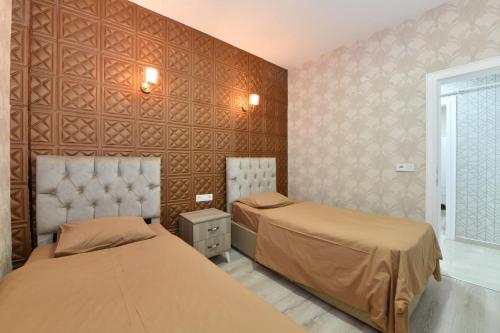 a bedroom with two beds and a wall at Dubleks Suite 4-1 in Istanbul
