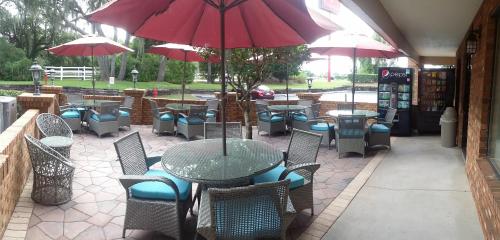 a patio with a table and chairs and umbrellas at Ramada by Wyndham Temple Terrace/Tampa North in Tampa