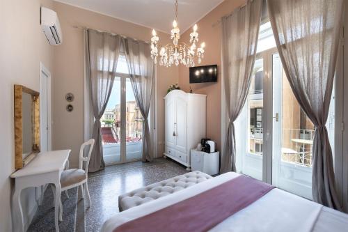 a bedroom with a bed and a chandelier at xenìa in Siracusa