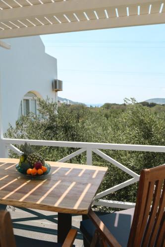 a wooden table with a bowl of fruit on a balcony at Villa Katapoliani No.3 in Katapola