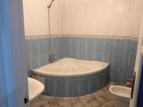 y baño con bañera, aseo y lavamanos. en Appartement en Agadir