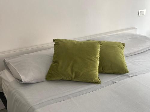 - un lit blanc avec 2 oreillers jaunes dans l'établissement Casetta rosa Taormina, à Taormine