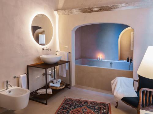 a bathroom with a sink and a tub at Masseria Monè in Monopoli