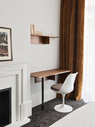 a desk and a chair in a room with a fireplace at Hotel De Verdun 1882, BW Signature Collection in Lyon