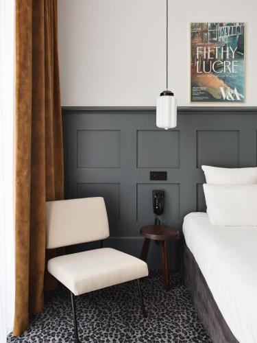 a bedroom with a bed and a chair at Hotel De Verdun 1882, BW Signature Collection in Lyon