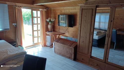 a bedroom with a bed and a tv in a room at Landurlaub im kleinen Holzhaus in Ulrichshorst