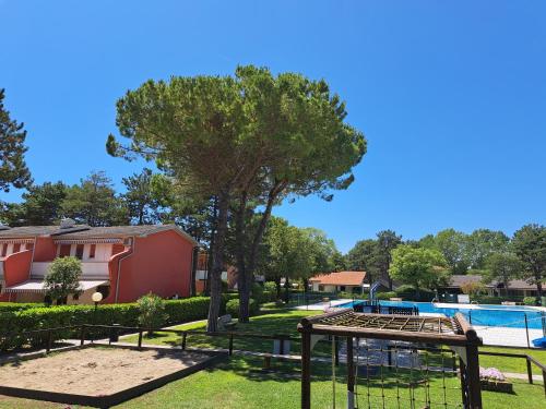 uitzicht op een park met een zwembad bij Adriella apartments in Bibione