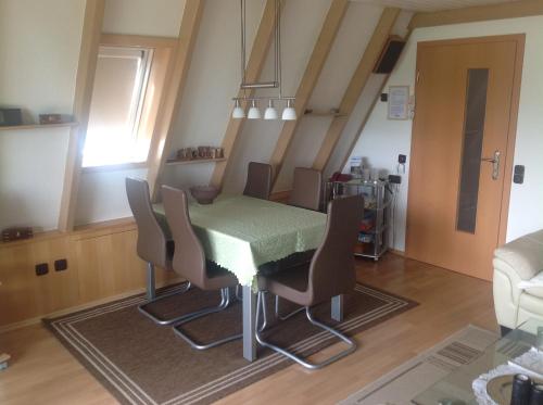 ein Esszimmer mit einem grünen Tisch und Stühlen in der Unterkunft Ferienhaus Kreuzberglick in Bischofsheim an der Rhön