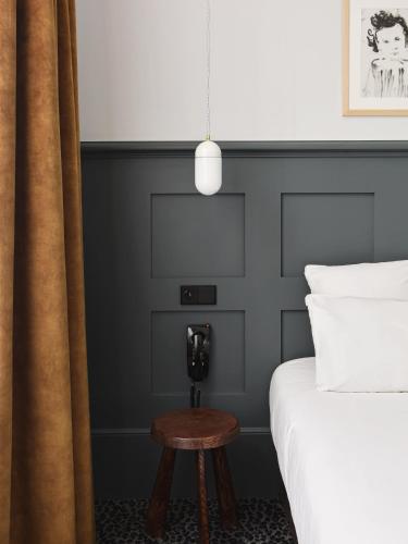 a bedroom with a black headboard and a table next to a bed at Hotel De Verdun 1882, BW Signature Collection in Lyon