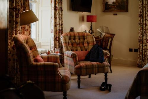 a living room with two chairs and a lamp at Links House at Royal Dornoch in Dornoch