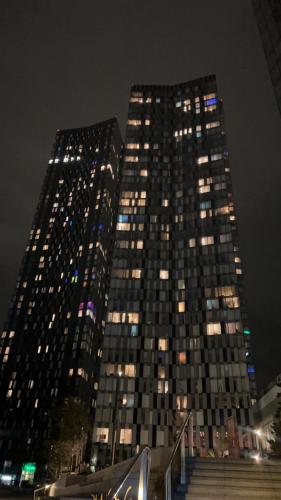 a tall building with lights in front of it at Panoramic Views High Floor Apartment in Manchester