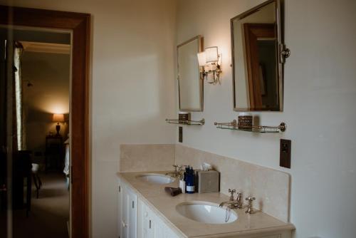 a bathroom with two sinks and a mirror at Links House at Royal Dornoch in Dornoch