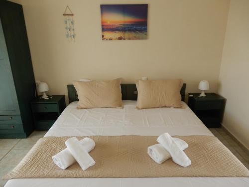 a bedroom with a bed with two crosses on it at Villa Teozenia in Achladies