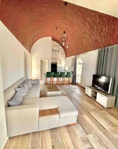 a living room with a white couch and a television at Azzurra two-bedrooms apartment at Sahl Hasheesh in Hurghada