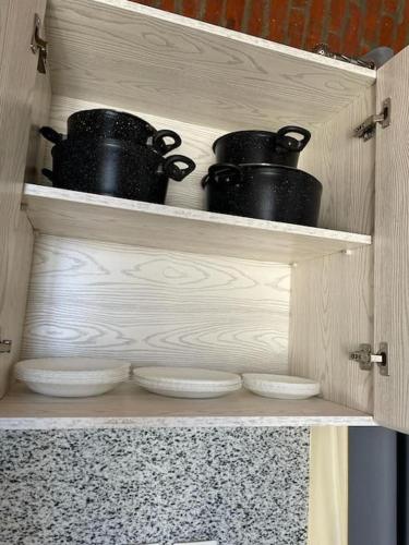 a wooden cabinet with black pots and pans on it at Azzurra two-bedrooms apartment at Sahl Hasheesh in Hurghada