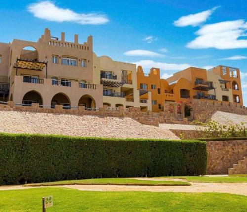 a large building with a hedge in front of it at Azzurra two-bedrooms apartment at Sahl Hasheesh in Hurghada