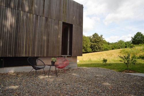 two chairs and a table in front of a building at Au Vieux Chêne in Malmedy