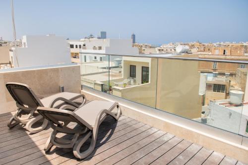 a pair of chairs sitting on top of a roof at Privilege Suit SLiema in Sliema