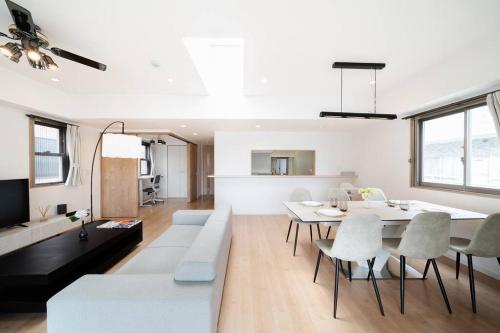 a white living room with a white table and chairs at Generous Forest 301 in Tokyo