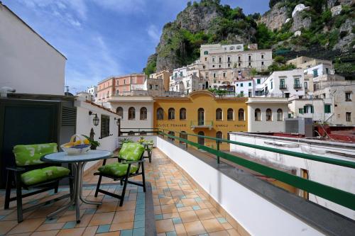 a balcony with a table and chairs and buildings at MeFra Camere - Amalfi Coast in Atrani