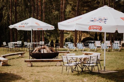 a group of chairs and tables and umbrellas at Domek Na Gwizdówce " u KARGULA" - KASZUBY in Sierakowice