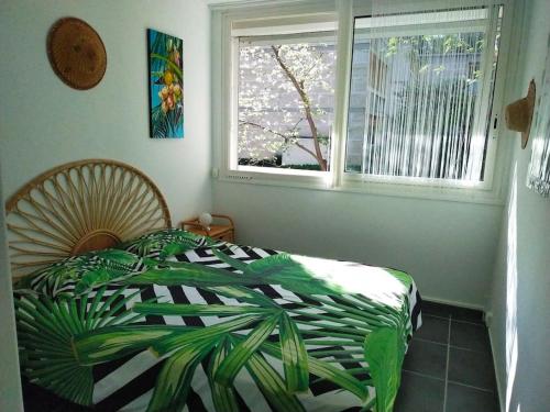 a bedroom with a bed with a green and white blanket at Cigalou 2km Marina Olympique - Parking gratuit in Marseille