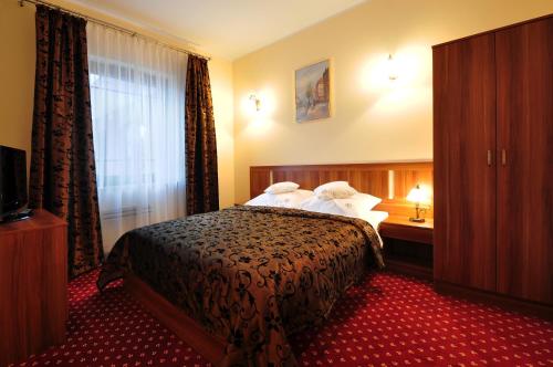 um quarto de hotel com uma cama e uma janela em Apartamenty Continental em Krynica Morska