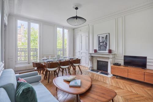 a living room with a table and a fireplace at Residence Le Marais by Studio prestige in Paris