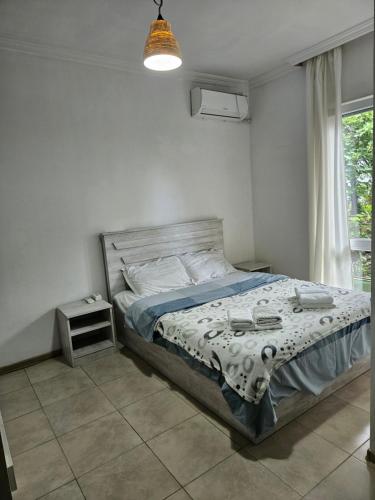um quarto com uma cama e uma janela em Junona em Makhinjauri