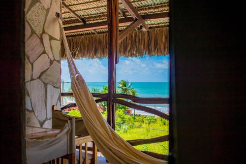 a hammock in a room with a view of the ocean at Castelo Beach Hotel in Natal