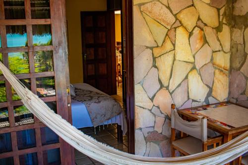 a hammock in a room with a rock wall at Castelo Beach Hotel in Natal