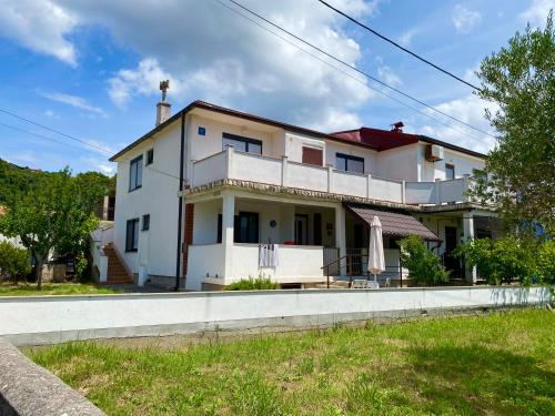 a large white house on a street at Guesthouse Šimag in Rab